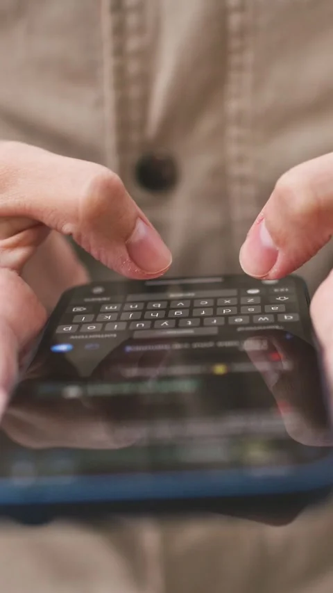 Close-up view of person typing message on smartphone screen using both thumbs Stock Footage 314256959