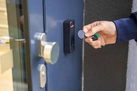Close up view of person using a electric lock key fob to access a building via a 写真素材