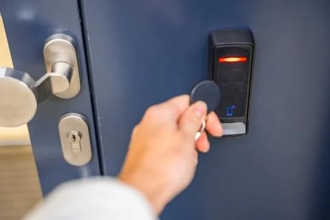 Close up view of person using a electric lock key fob to access a building via a Stock Photos