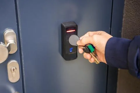 Close up view of person using a electric lock key fob to access a building via a Stock Photos