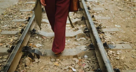 Close-up view of a person walking along the iconic train tracks of Train Street Stock Footage 338008055