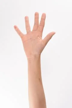 Close-up view of a person's hand raised with fingers spread wide. The hand an Stock Photos