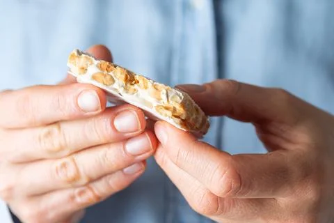 A close-up view of a person's hands holding a broken piece of traditional w.. Stock Photos