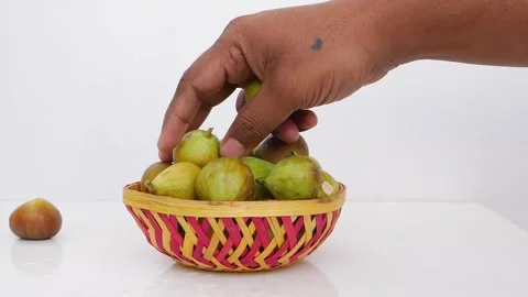 Close view of picking up green fig fruits from a craft bowl Stock Footage 148214220