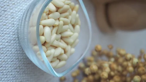 A close-up view of pine nuts in clear glass bowl with blurred background. Stock Footage 332041293