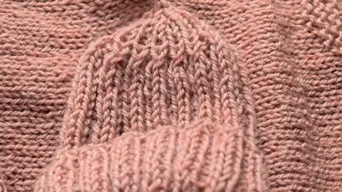 A close-up view of a pink knitted sweater Stock Footage 347447142