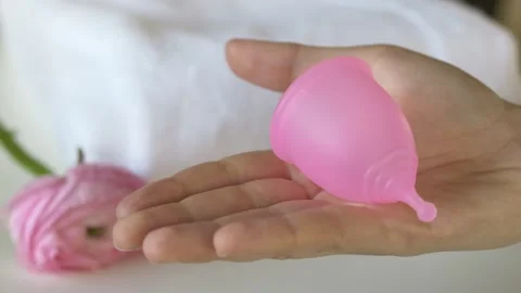 Close up view of pink silicone menstrual cup in hand. Educational demonstration Stock Footage 330459955