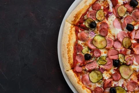 Close up view of pizza with defferent kind of sausages, pickled cucumber, oli Stock Photos