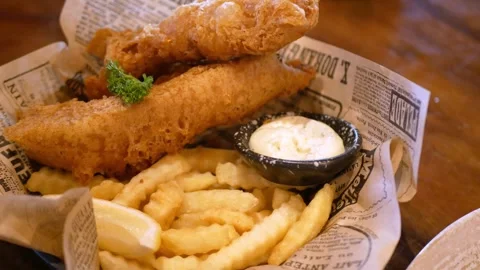 Close up view to a plate of fish and chips with tartar sauce for dinner lun.. Video stock 254153345