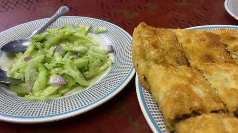 Close Up View Of Plate Of Salad Beside Plate Full Of Mughlai Paratha. Slow 스톡 동영상 228705284