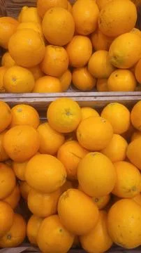 Close-up view of a plentiful mound of oranges in a market stall, ideal for Stock Photos