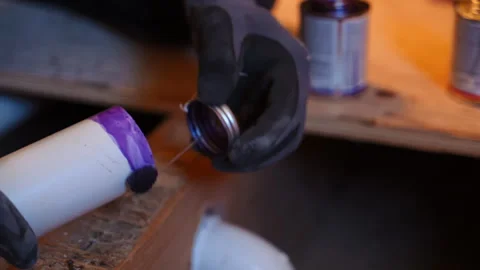 Close up view of Plumber applying purple primer to a PVC pipe fitting during Stockbeeldmateriaal 346802226