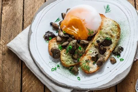 Close view of poached egg with wild mushrooms and toasted bread Stock Photos