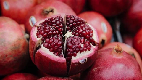 Close up view of pomegranate fruit that is lying down on heap of fruits in the Stock Footage 181648809