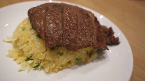 Close-up view of the pork chop egg fried rice on the plate. 動画素材 237929797