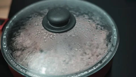 Close-up view of a pot with a lid, showing condensation forming on the glass, 스톡 동영상 337111917