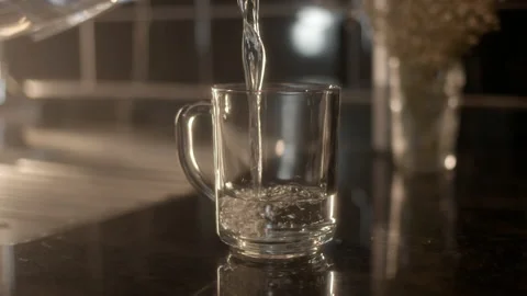 Close up view of pouring clear clean water from filter into glass mug in morning Stock Footage 232638579