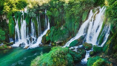 Close view of powerful cascading waterfalls flowing over moss covered rocks 写真素材