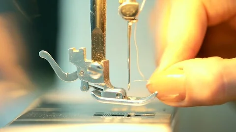 Close-up view on pressed foot of sewing machine, tailor threading needle Stock Footage 74155422