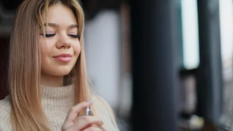 Close up view of pretty blonde young Caucasian woman using perfume in slow Stock Footage 104564516