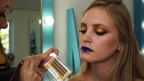 Close up view on process of applying fake eyelashes with glue and tweezers on Stock Footage 100143053