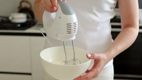 Close-up view of a professional chef or home baker using an electric hand mix Stock Footage 314036521
