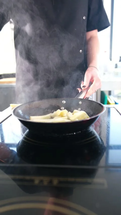 Close-up view of a professional chef wearing black gloves, adding raw sliced Stock Footage 318316392
