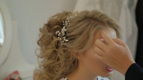 A close up view of a professional doing a wedding hairstyle for a beautiful girl Stock Footage 131231451