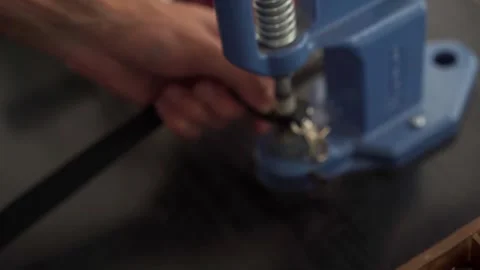 Close up view of professional leather craftsman attaches pin to handle of Stock Footage 256295783