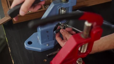 Close up view of professional leather craftsman attaches pin to zipper puller of Stock Footage 258212735