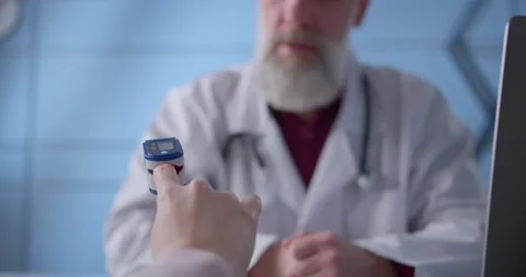 Close-up view of a pulse oximeter used on a patient during an appointment at a Video stock 148209593