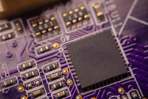 Close-up view of a purple printed circuit board featuring a central black m.. Stock Photos