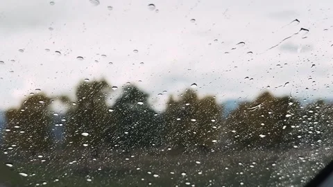 Close view of rain droplets on windshield while car moves Stock Footage 320896807