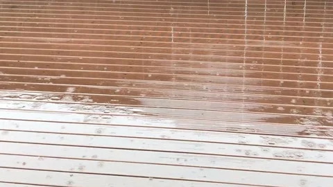Close up view of rain falling on rust stained deck during a winter day in Stock Footage 135271195