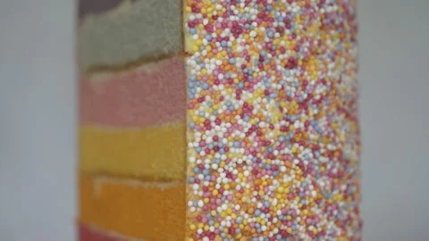 A close up view of a rainbow cake with sprinkled candy glazing. Stock Footage 152950291