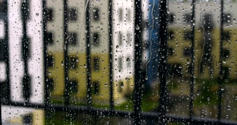 Close view of raindrops clinging to window glass with out of focus colorful Stock Footage 315693256