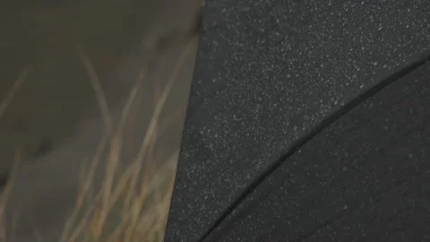 Close-up view of raindrops crushing against black umbrella Stock Footage 232270464