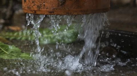 Close-up view of raindrops flowing down from the pipeline. A stream of water  Foto stock