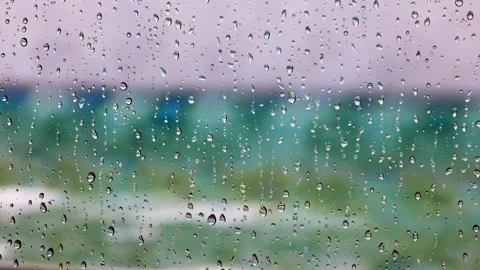 Close-up view of raindrops sliding down window with Atlantic Ocean waves Stock Footage 341237513