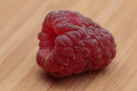 Close-up view of raspberry lying on wooden board Stock Photos