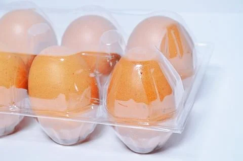 Close-up view of raw chicken eggs in egg box on white wooden background Stock Photos