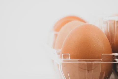 Close-up view of raw chicken eggs in egg box on white wooden background Stock Photos