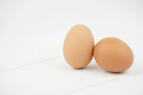 Close-up view of raw chicken eggs in egg box on white wooden background Stock Photos