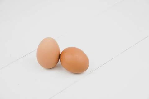 Close-up view of raw chicken eggs in egg box on white wooden background Stock Photos