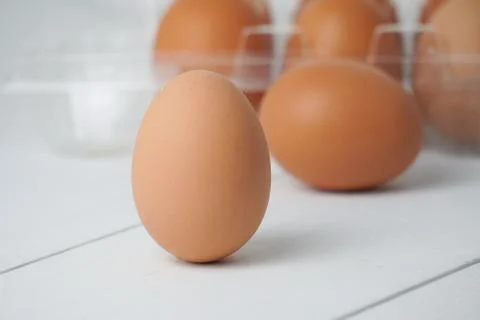 Close-up view of raw chicken eggs in egg box on white wooden background Stock Photos