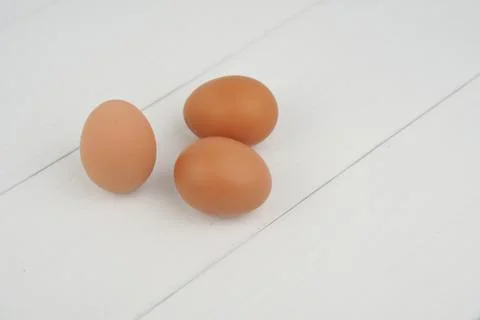 Close-up view of raw chicken eggs in egg box on white wooden background Fotos de archivo