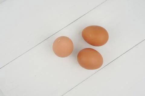 Close-up view of raw chicken eggs in egg box on white wooden background Stock Photos