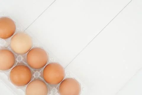 Close-up view of raw chicken eggs in egg box on white wooden background Stock Photos