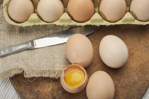 Close-up view of raw chicken eggs in egg box on wooden background. Raw chicke Foto stock