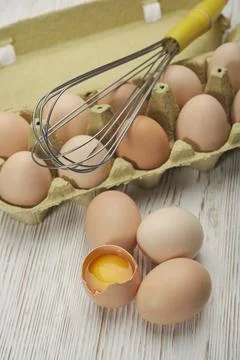 Close-up view of raw chicken eggs in egg box on wooden background. Raw chicke Stock Photos